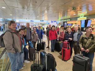 Eine Reisegruppe mit Koffern in der Bahnhofshalle