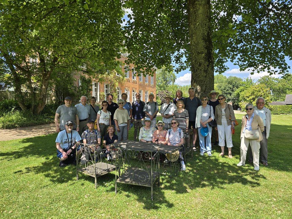 Das Foto zeigt die Gruppe der Mitreisenden und Gastgeber in einem Park unter einem Baum