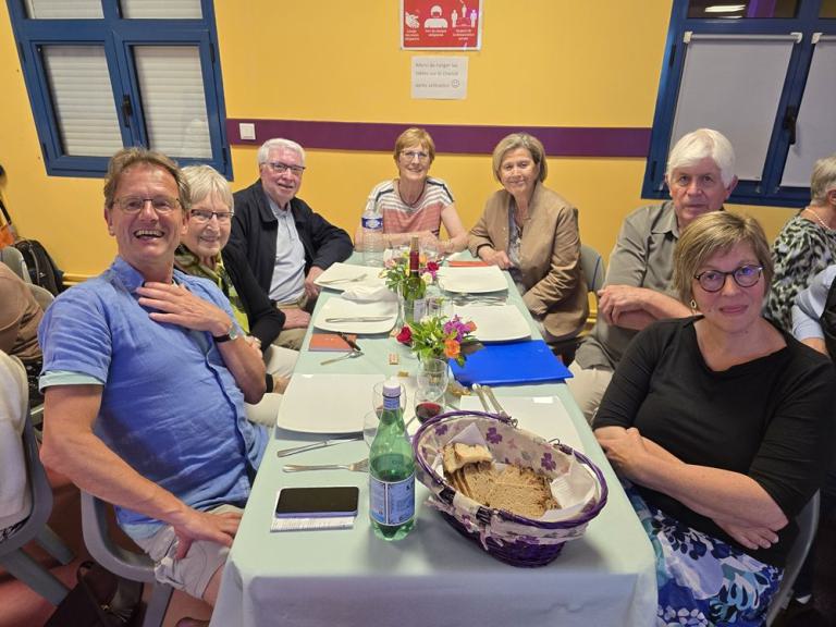 Eine Gruppe sitzt zum Essen an einem Tisch