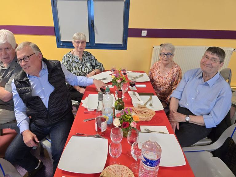 Eine Gruppe sitzt zum Essen an einem Tisch