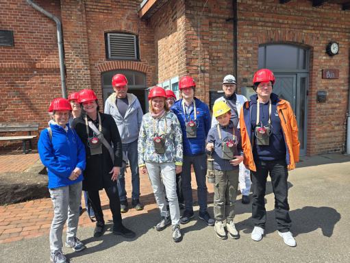 Gruppenfoto mit Grubenhelmen vor dem Gebäude des Zechensaals